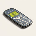 The Brick golf ball marker, a grey mobile phone with a raised keypad and a golfer on the screen, photographed at an angle.