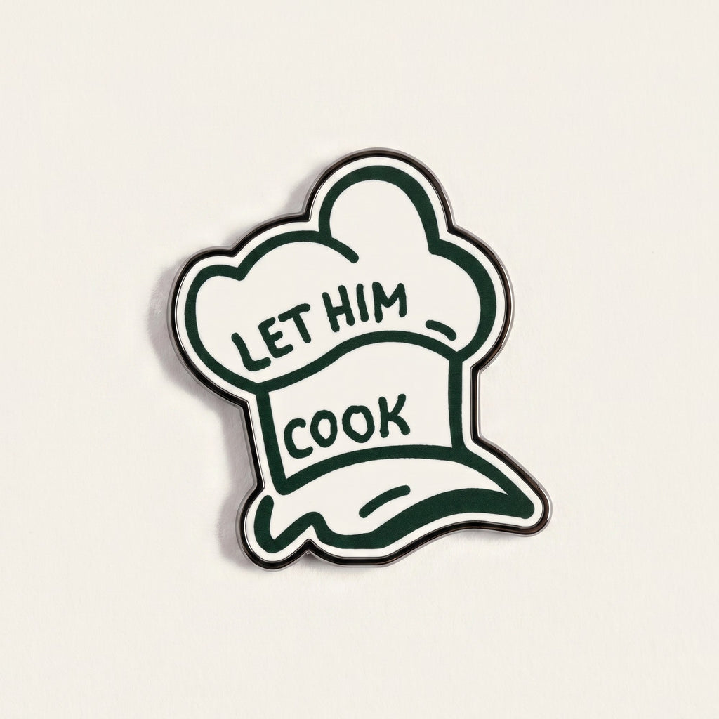 The Chef golf ball marker photographed flat from above, showing the full hat design and the black nickel edge.