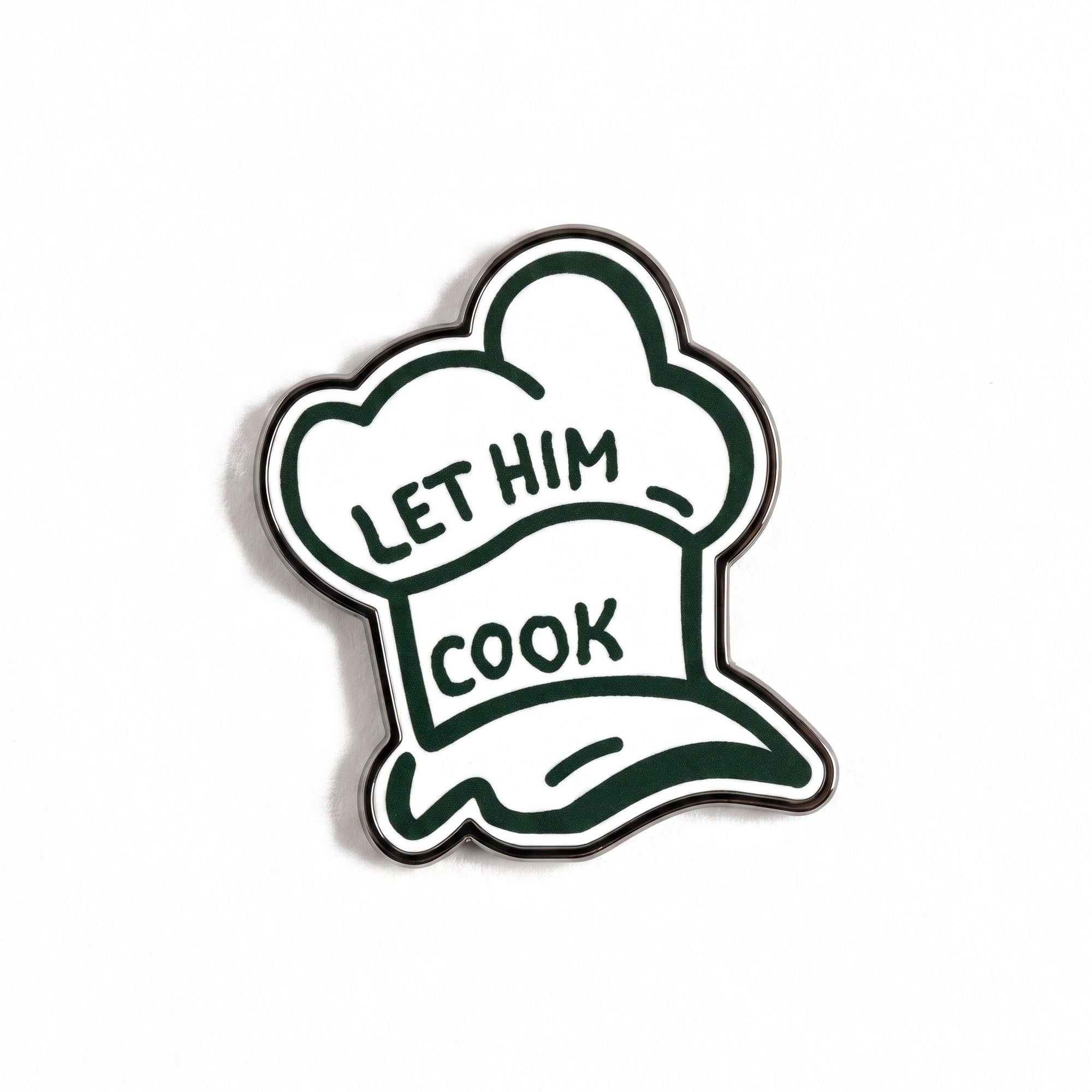 The Chef golf ball marker photographed flat from above, showing the full hat design and the black nickel edge.