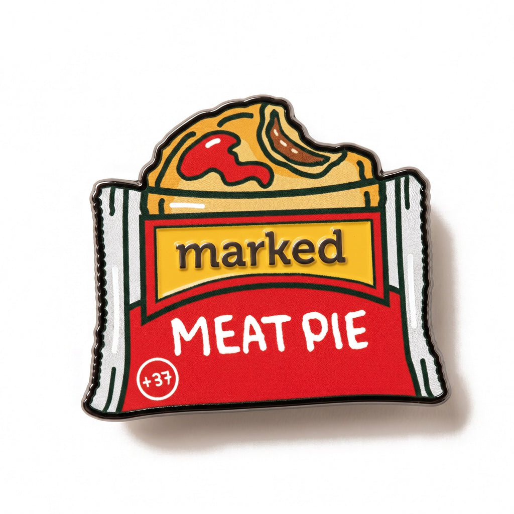 The Meat Pie golf ball marker photographed flat from above, showing the full design and the black nickel edge.