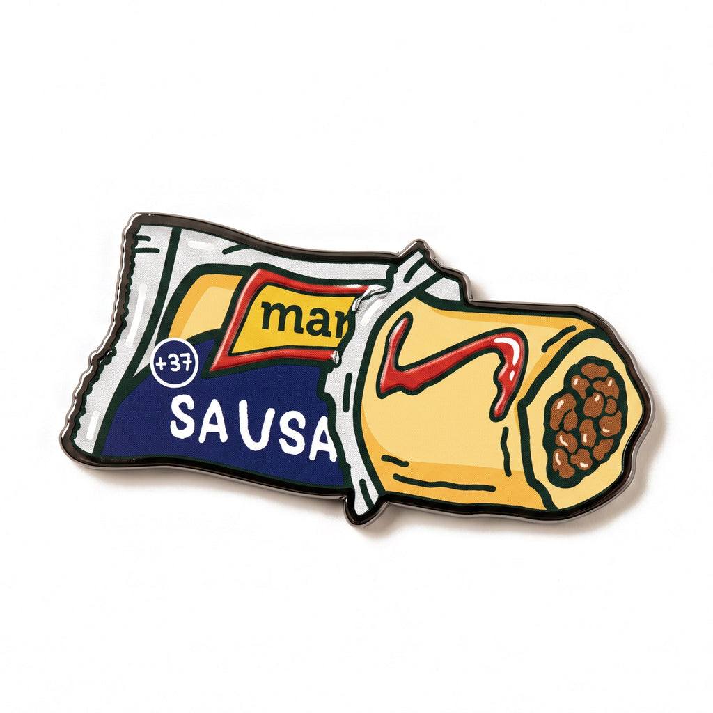 The Sausage Roll golf ball marker photographed flat from above, showing the full design and the black nickel edge.
