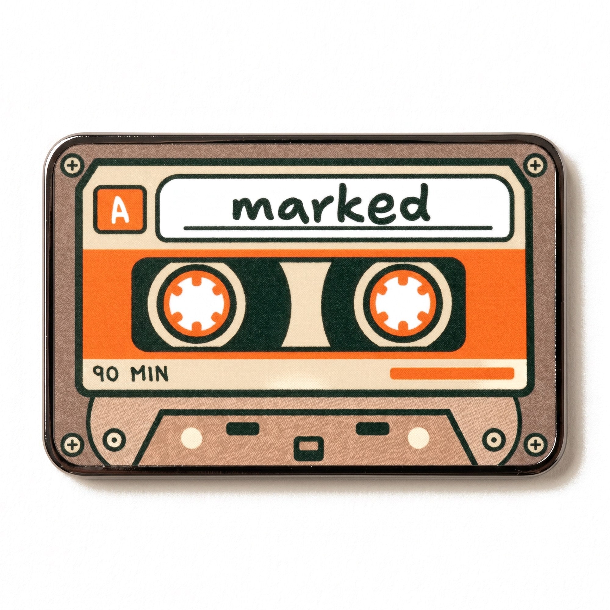 The Soundtrack golf ball marker photographed flat from above, showing the full cassette design and the black nickel edge.